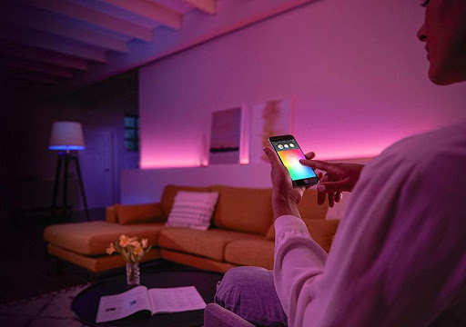 Layered lighting design in an open-plan living room with ambient, task, and accent lights.